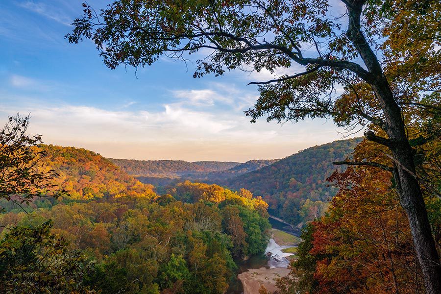Blog - Mammoth Cave National Park, Seen From an Overlook, the Mountains Stretching Into the Distance, Trees Turning Orange, a Bright Blue Sky Overhead